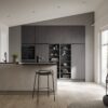 Häcker Designküche mit Tresen Zement, helle Zeile in Zementoptik mit Tresen und Hochschrankwand in Anthrazit